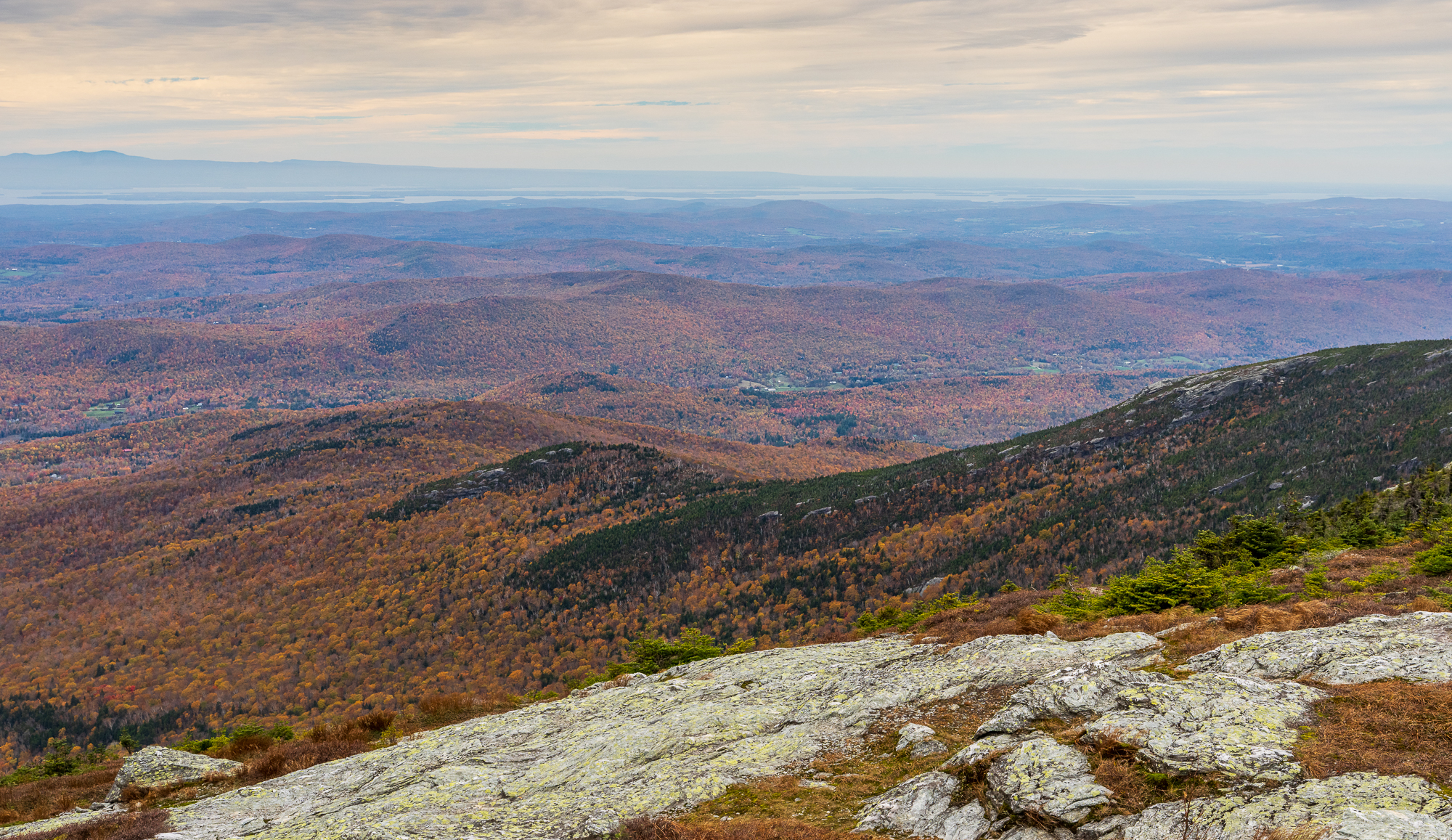 The Adirondack Mountains on the horizon, seen from the rocky summit ridge of Mount Mansfield