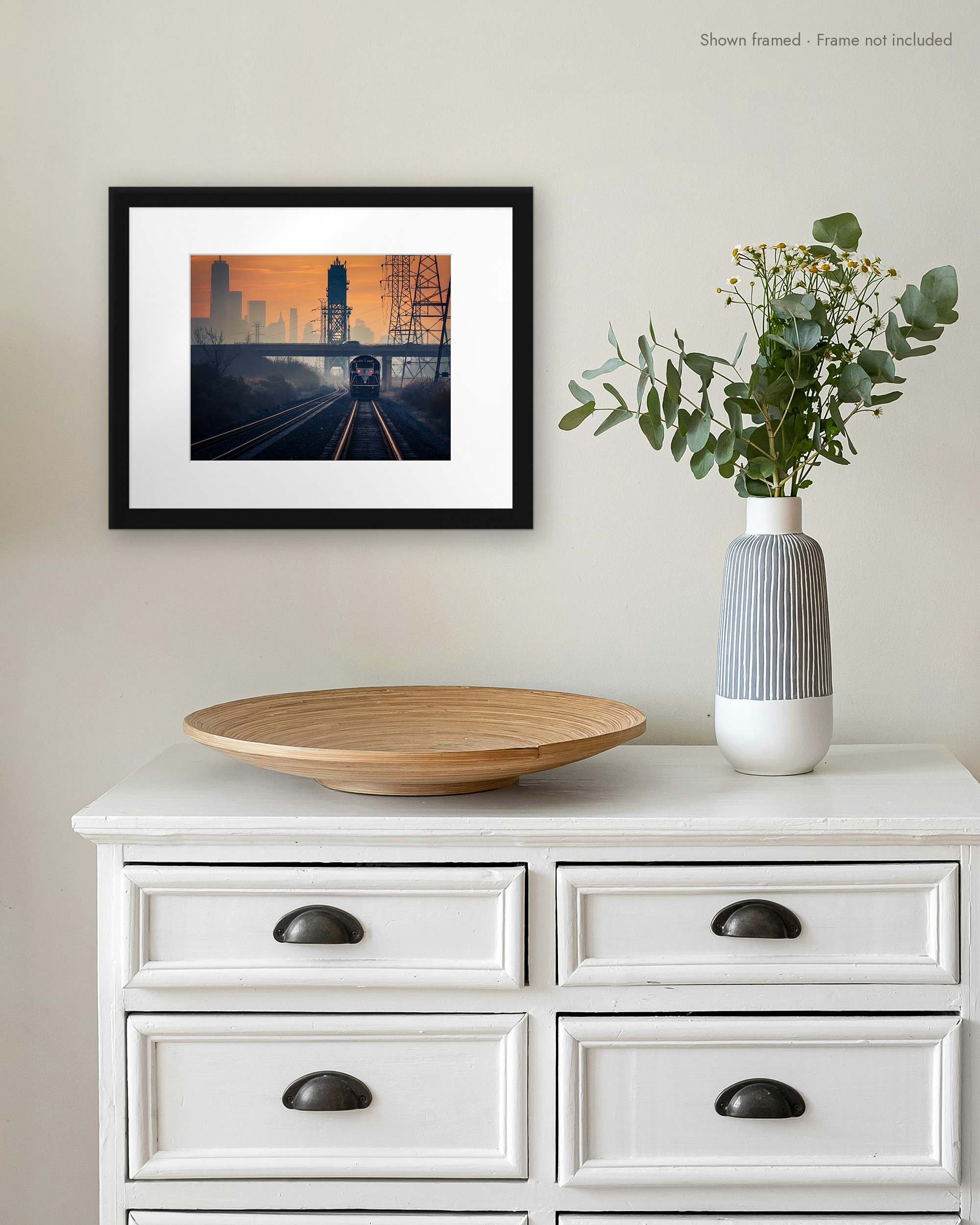 Meadowlands Express print in a white mat and black frame on a wall above a white dresser
