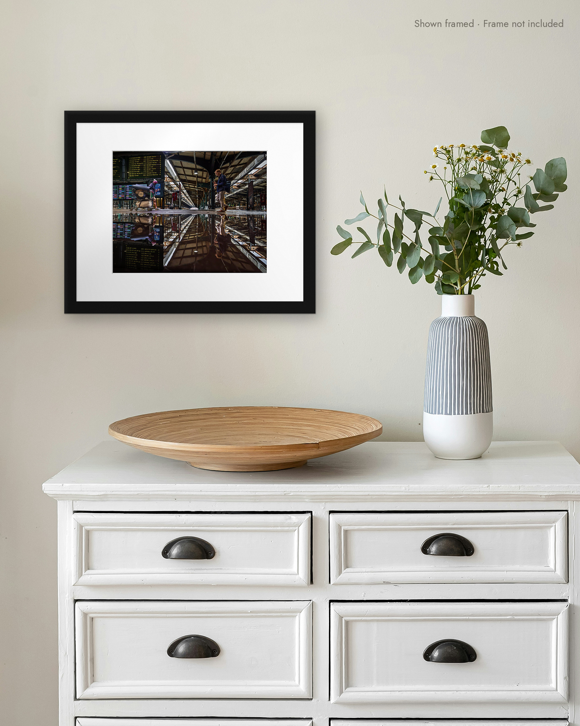 Terminal Reflected print in a white mat and black frame on a wall above a white dresser