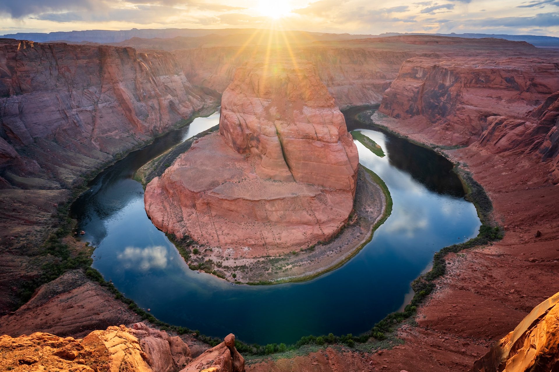 Horseshoe Bend on the Colorado River with the sun bursting over the rim